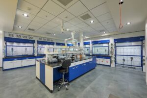 Fume hood integrated with lab furniture in a coating and resin manufacturing facility, designed for safe chemical handling and effective ventilation.