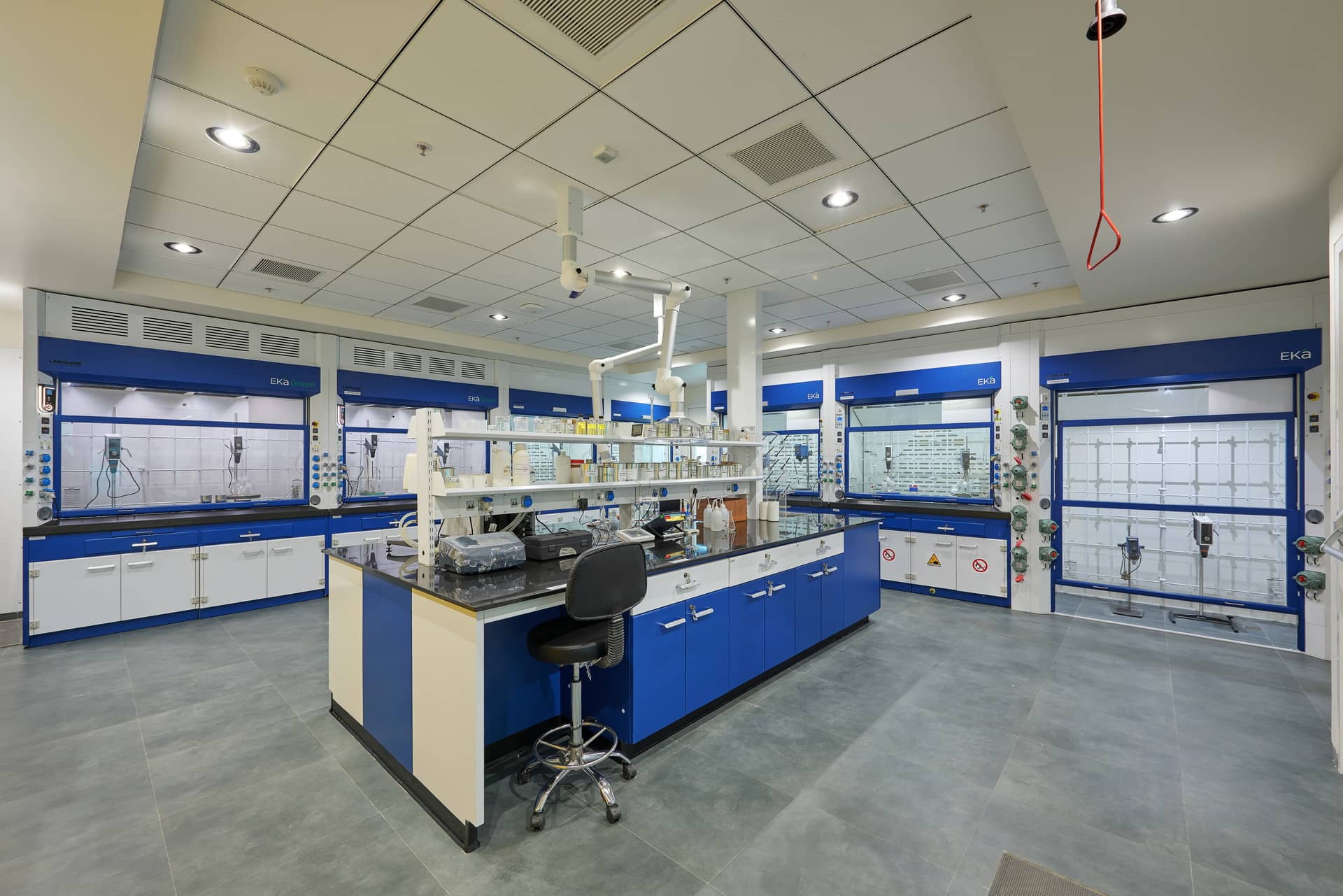 Fume hood integrated with lab furniture in a coating and resin manufacturing facility, designed for safe chemical handling and effective ventilation.